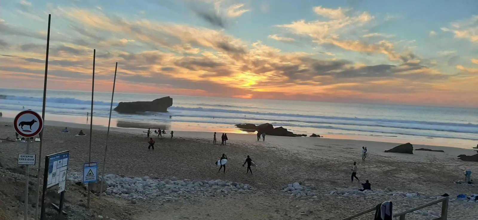 Walkers on the beach at sunset in the western Algarve